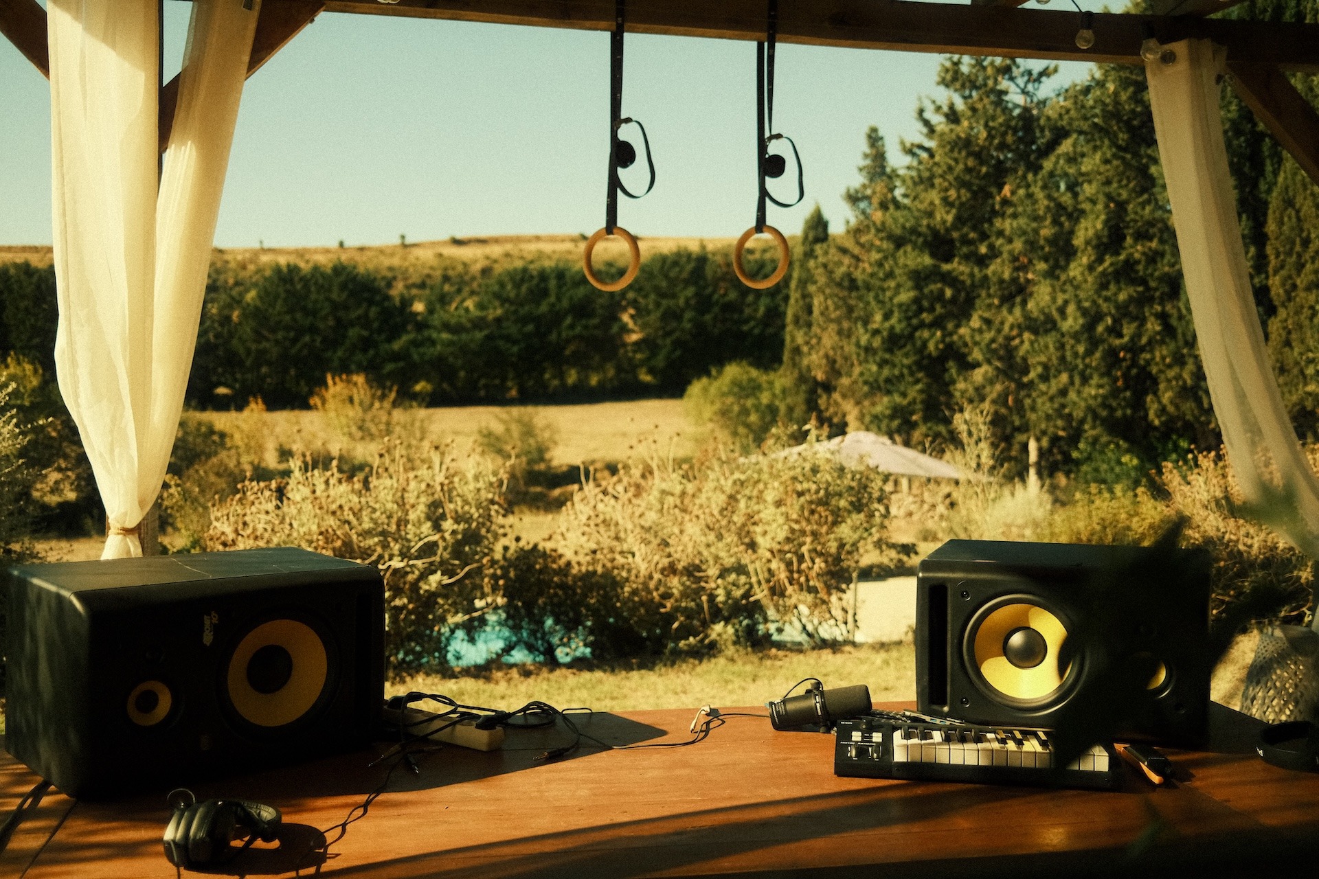 Studio monitor speakers by an open window overlooking the garden