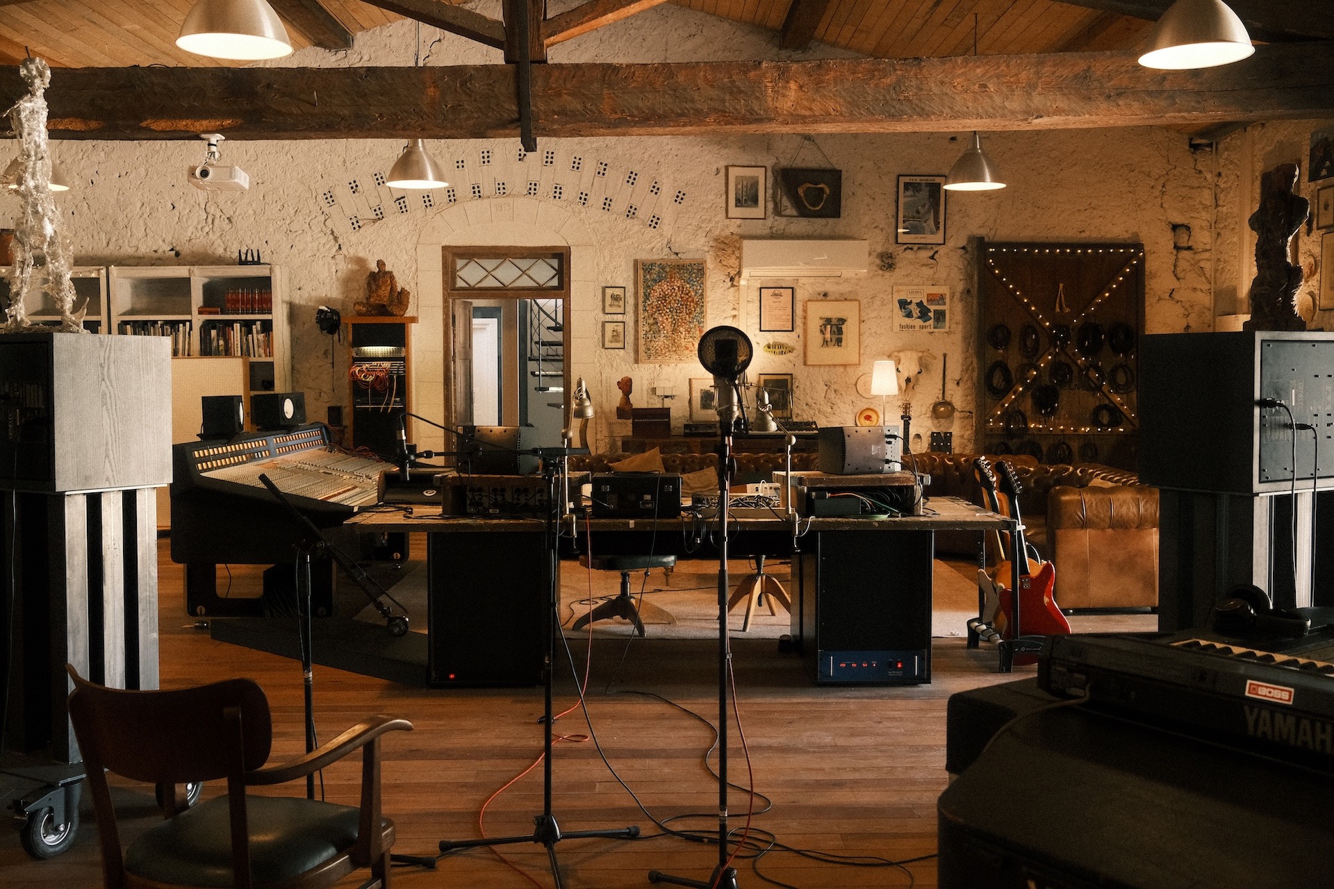 Large live room studio with instruments, microphones and wall art