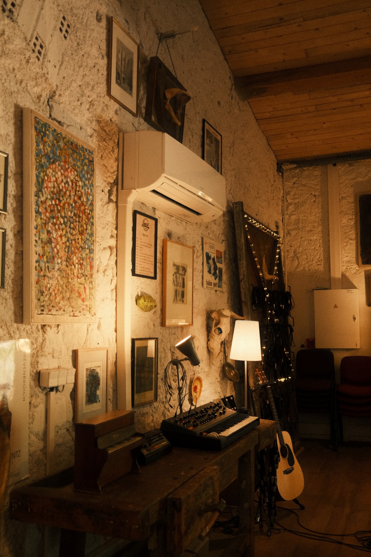 Studio wall with framed pictures and a reading lamp