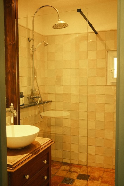 A tiled bathroom with sink and mirror in the guest house